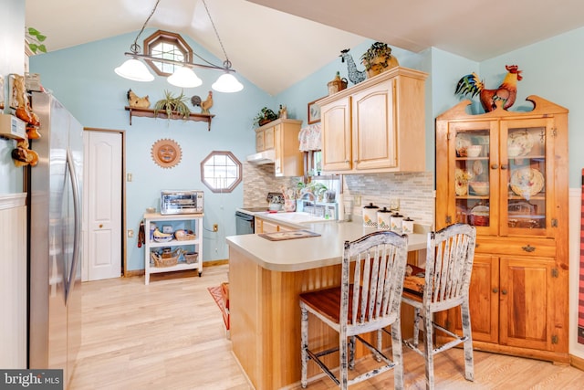 kitchen featuring stainless steel appliances, light wood-type flooring, pendant lighting, a breakfast bar area, and kitchen peninsula