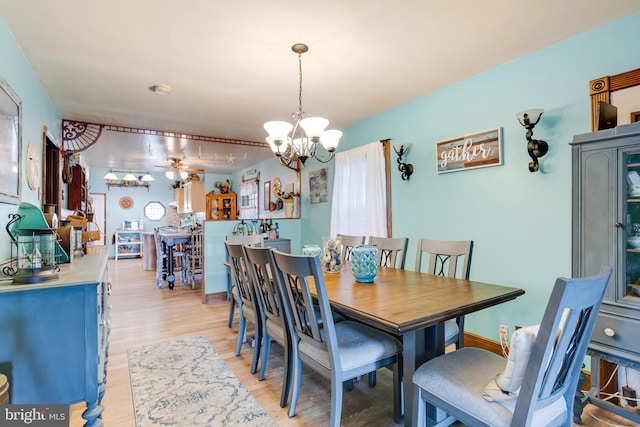 dining area featuring light hardwood / wood-style floors and ceiling fan with notable chandelier