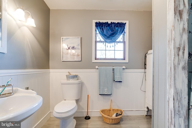 bathroom with hardwood / wood-style flooring, toilet, and sink