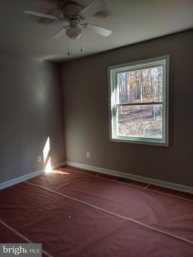 carpeted spare room with ceiling fan