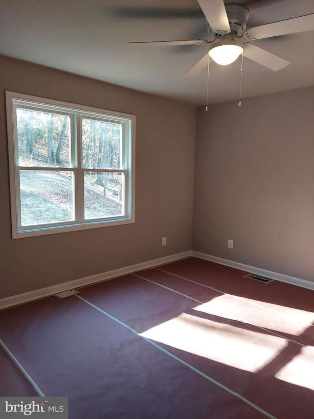 unfurnished room with dark carpet and ceiling fan