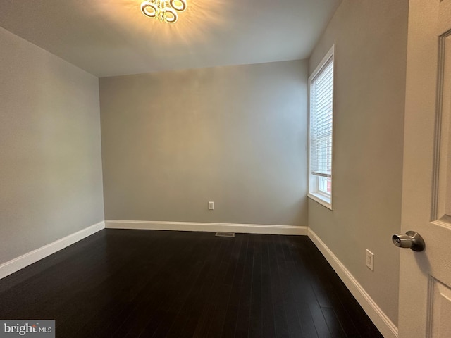 spare room featuring hardwood / wood-style flooring and a healthy amount of sunlight