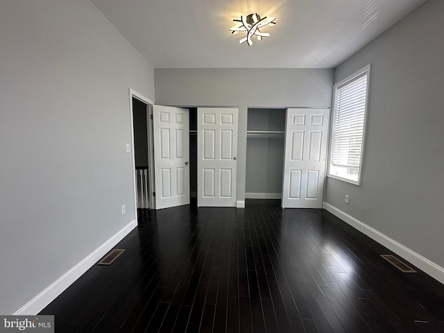 unfurnished bedroom with dark hardwood / wood-style flooring