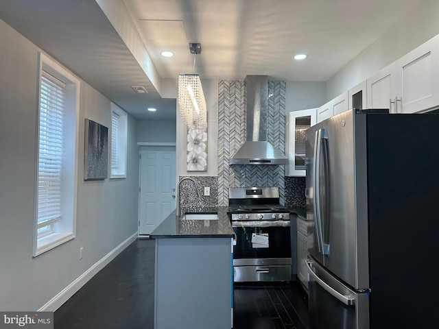 kitchen with stainless steel appliances, plenty of natural light, sink, wall chimney range hood, and white cabinetry