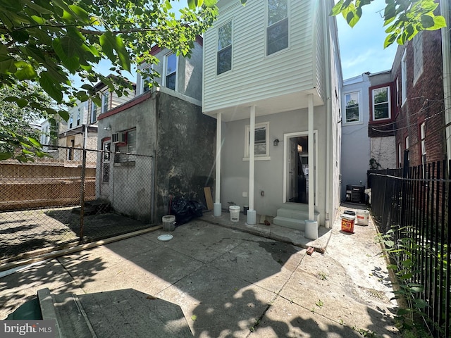 rear view of house featuring central AC