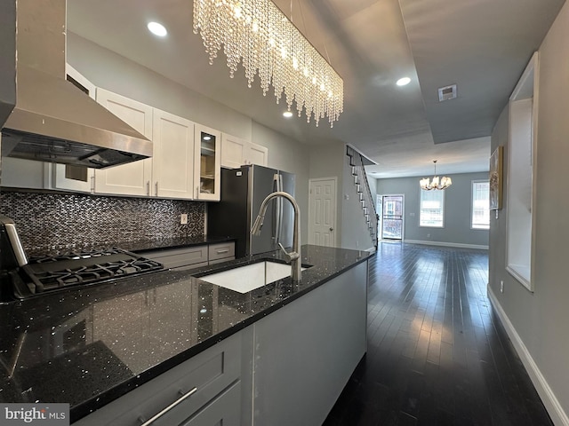 kitchen with ventilation hood, dark stone counters, dark hardwood / wood-style floors, pendant lighting, and white cabinets