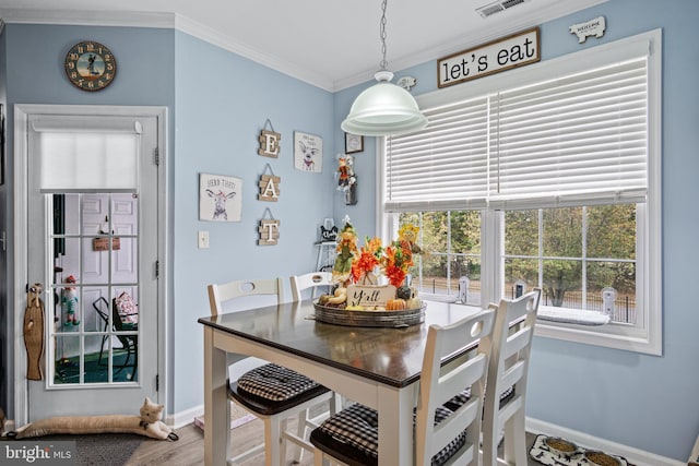 dining area featuring hardwood / wood-style floors and ornamental molding