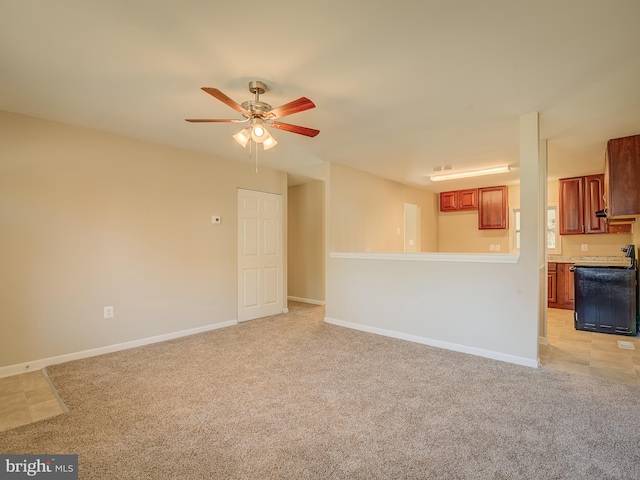 unfurnished living room featuring light carpet and ceiling fan