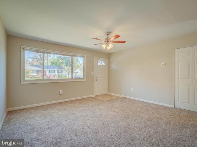 spare room featuring ceiling fan and light carpet