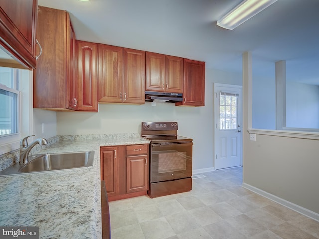 kitchen featuring black electric range, light stone countertops, and sink