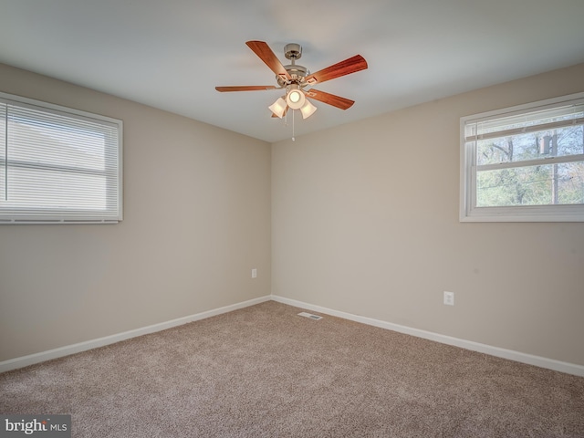 carpeted spare room with ceiling fan