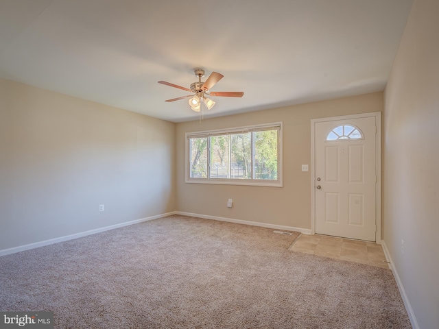 carpeted entrance foyer with ceiling fan