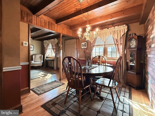 dining area featuring beamed ceiling, wood ceiling, and light hardwood / wood-style floors