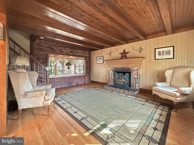 unfurnished room featuring wood-type flooring, a fireplace, beam ceiling, wooden walls, and wooden ceiling