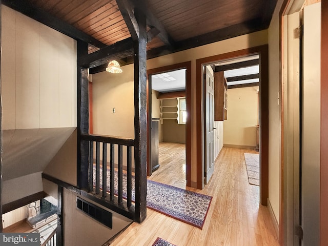 corridor with beamed ceiling, wood ceiling, and light hardwood / wood-style flooring