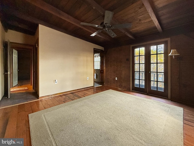 spare room featuring lofted ceiling with beams, wood-type flooring, and ceiling fan