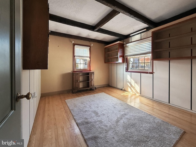 bonus room featuring beamed ceiling, a textured ceiling, and light wood-type flooring