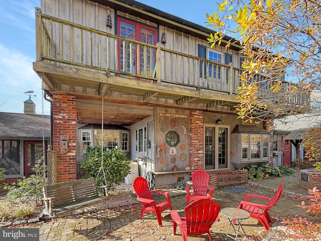 rear view of property featuring a patio and a balcony