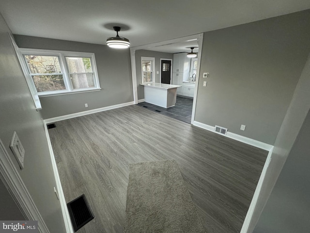 unfurnished living room with ceiling fan, sink, and dark hardwood / wood-style floors