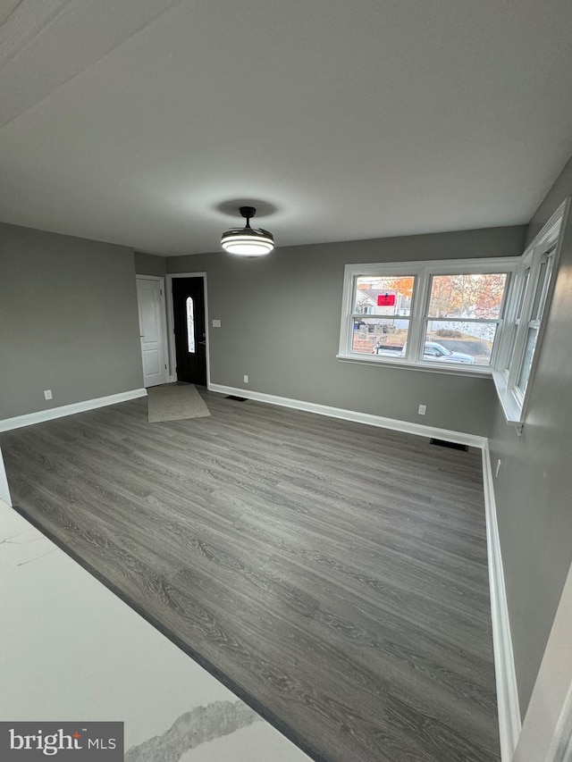 unfurnished living room with dark hardwood / wood-style floors