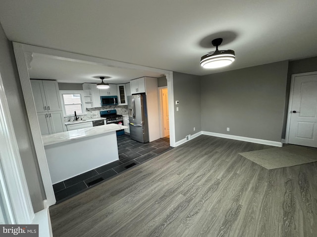 kitchen featuring white cabinetry, dark wood-type flooring, stainless steel appliances, and sink