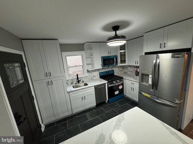 kitchen with decorative backsplash, appliances with stainless steel finishes, white cabinetry, and sink