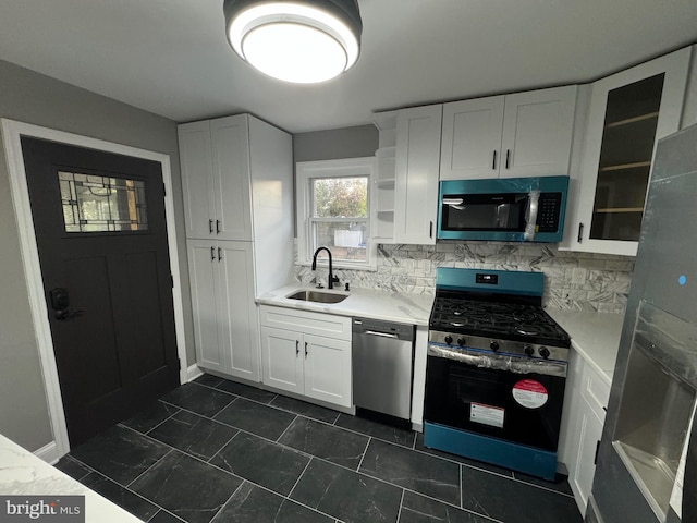 kitchen featuring white cabinets, backsplash, sink, and stainless steel appliances