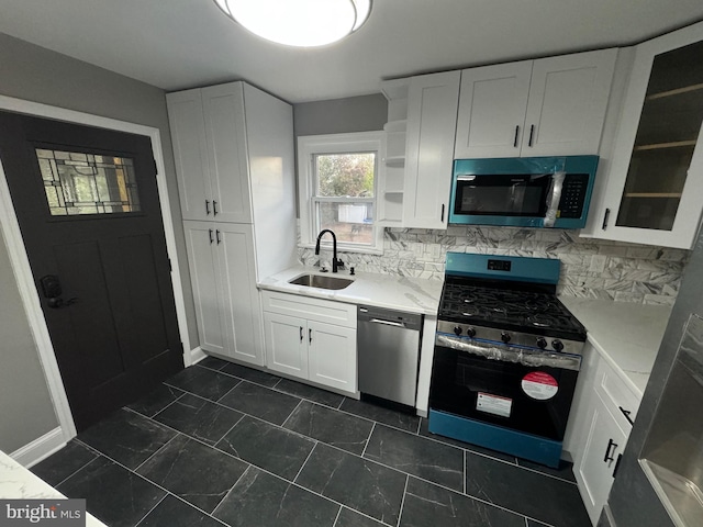 kitchen featuring sink, white cabinetry, stainless steel appliances, and tasteful backsplash