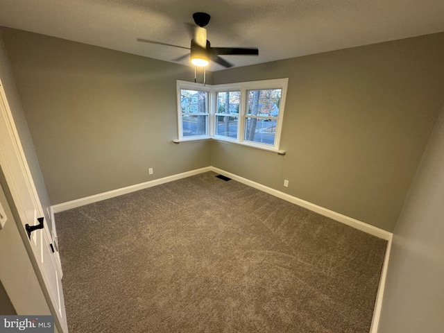 carpeted spare room with ceiling fan and a textured ceiling