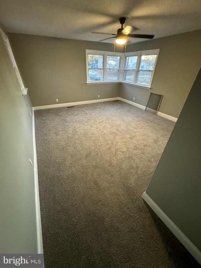 carpeted spare room with ceiling fan and a textured ceiling