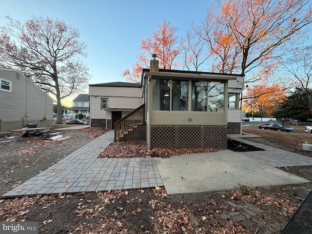 rear view of property featuring a sunroom