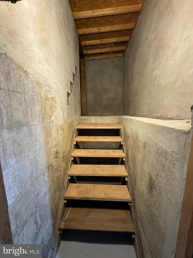 stairs featuring concrete flooring