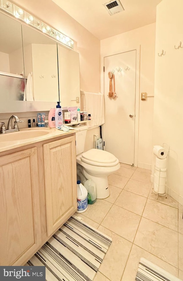 bathroom with toilet, an enclosed shower, vanity, and tile patterned floors