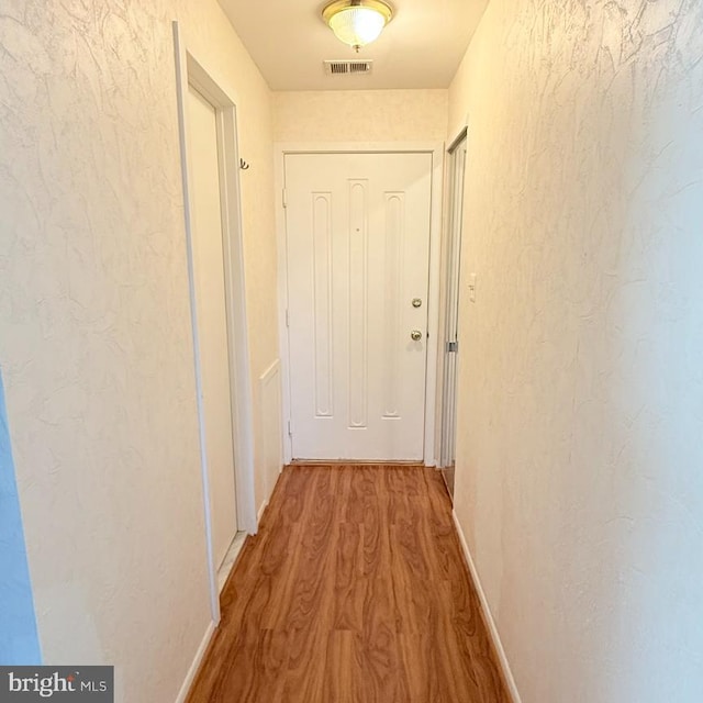 hallway with hardwood / wood-style floors