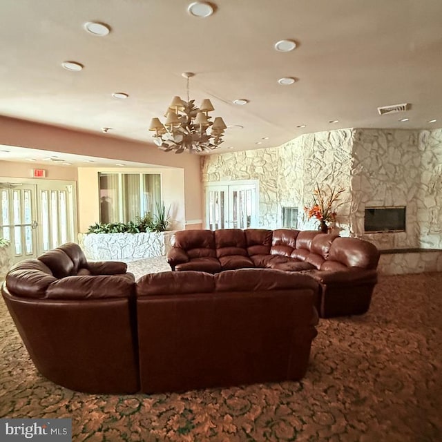 living room featuring carpet flooring, a fireplace, and an inviting chandelier