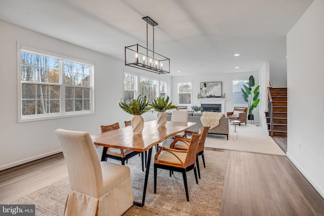 dining space featuring light wood-type flooring, a wealth of natural light, and an inviting chandelier