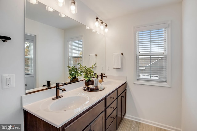 full bathroom featuring double vanity and baseboards