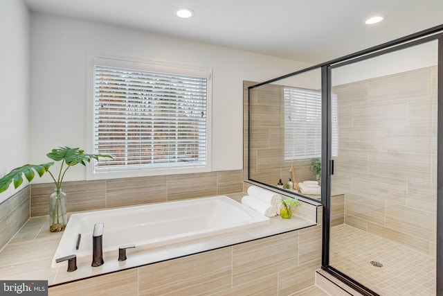 bathroom featuring separate shower and tub