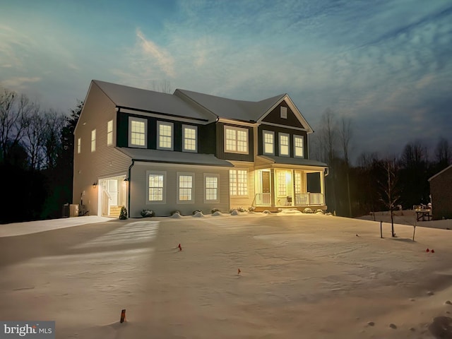 back of house at twilight featuring a porch and driveway