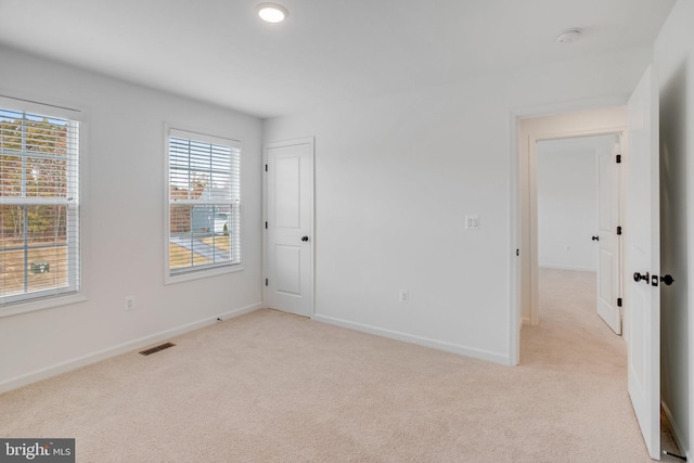 spare room featuring light colored carpet