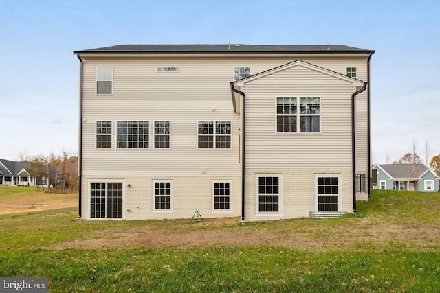rear view of property featuring a lawn