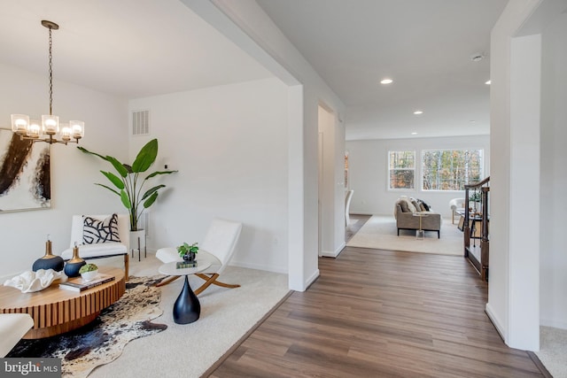 corridor featuring hardwood / wood-style flooring and a notable chandelier