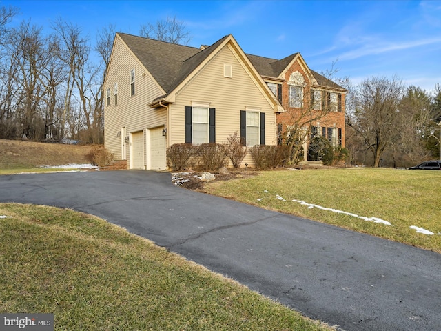 view of front property featuring a front lawn and a garage