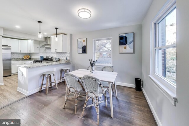 dining space with hardwood / wood-style floors and sink