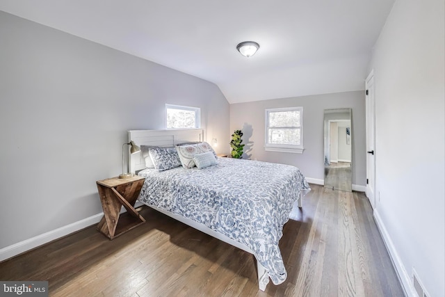 bedroom featuring hardwood / wood-style flooring, multiple windows, and lofted ceiling