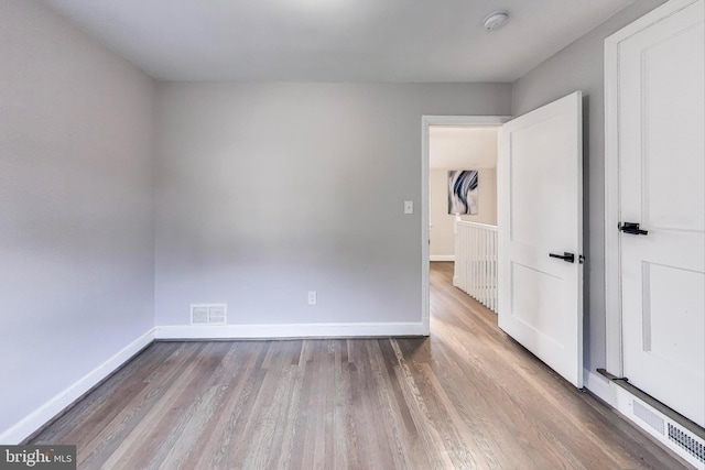 unfurnished room with hardwood / wood-style flooring