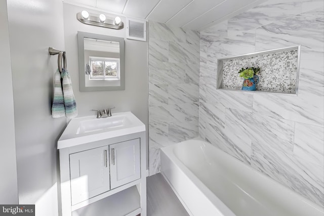 bathroom with vanity and tiled shower / bath combo