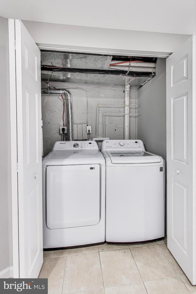 laundry room featuring washer and dryer and light tile patterned floors