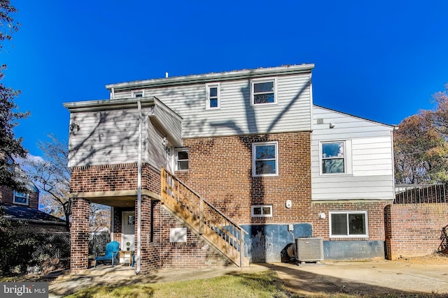 rear view of property with cooling unit and a patio area