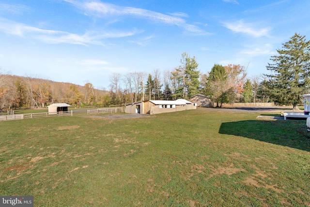 view of yard with an outbuilding and a rural view